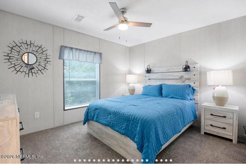 140 Islander Road Satsuma, FL 32189 - Photo 8 of 11 a bedroom with a bed and a chandelier