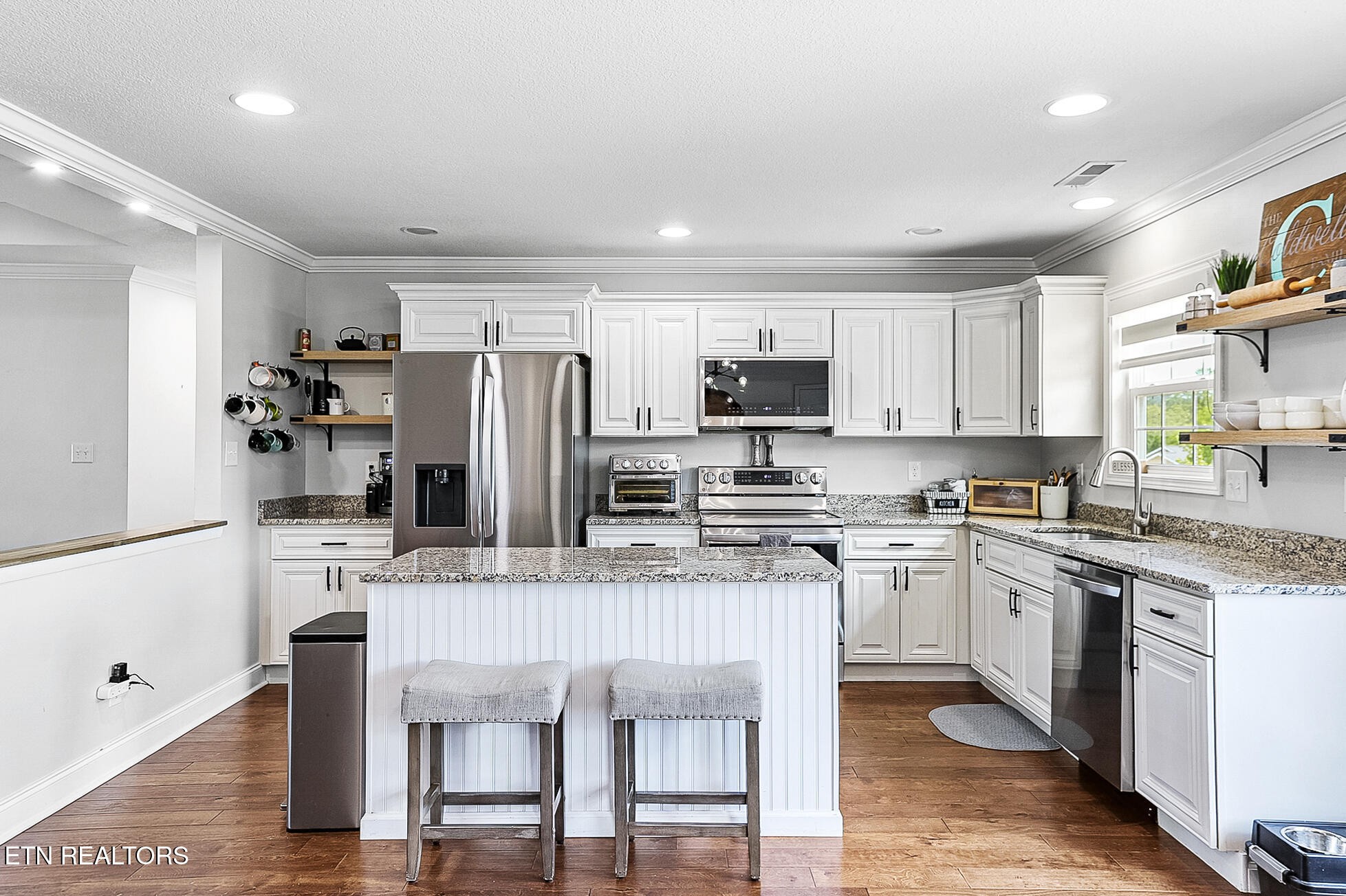 437 Covenant Way Seymour, TN 37865 - Photo 6 of 41 a kitchen with stainless steel appliances granite countertop a microwave a stove a sink dishwasher a refrigerator and white cabinets with wooden floor
