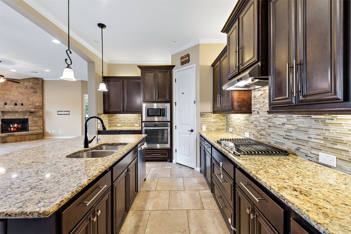 2000 Manada Trail Leander, TX 78641 - Photo 14 of 36 A well-appointed kitchen showcasing a spacious island with a sink and a gas cooktop.