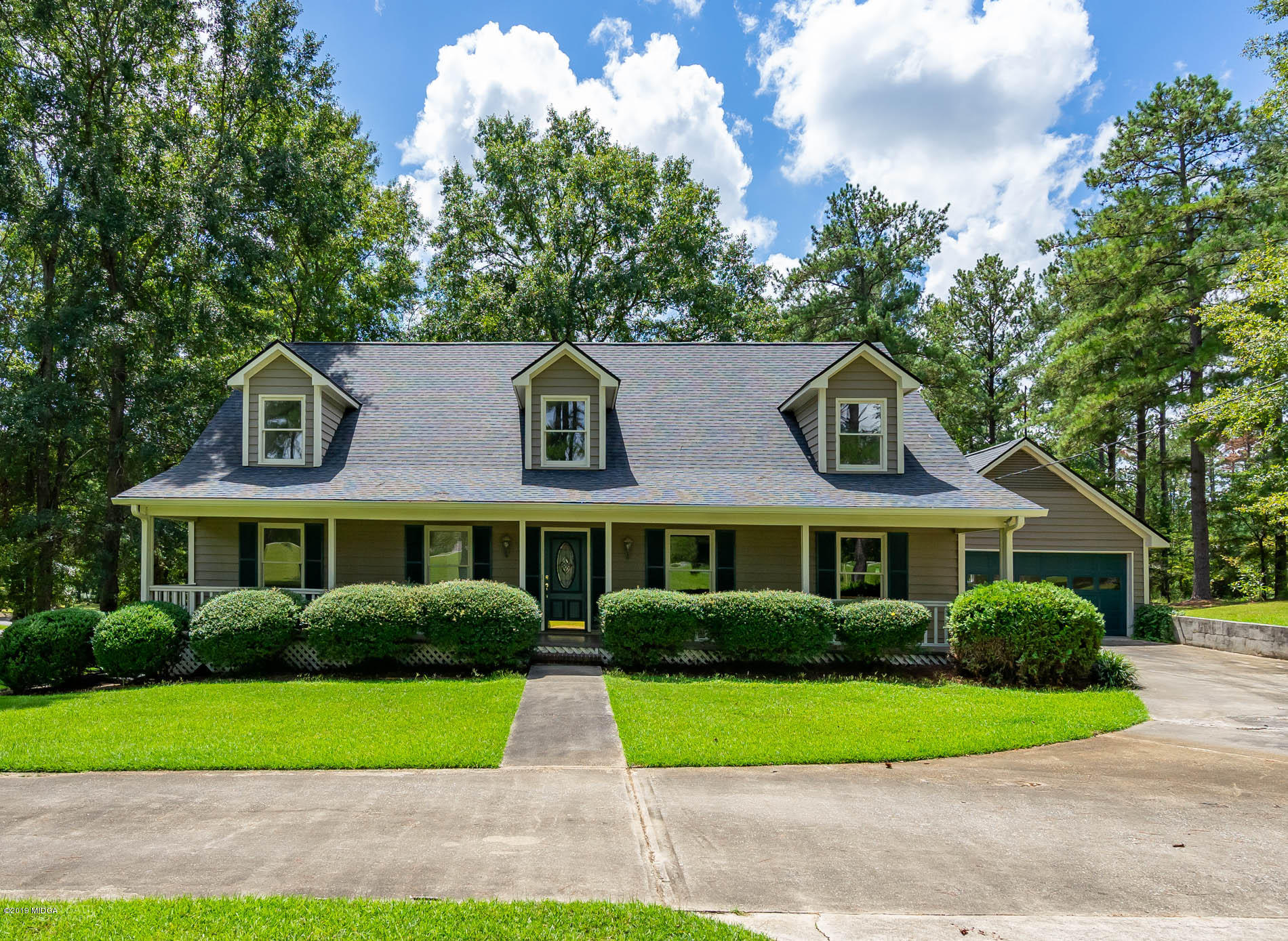 1041 Pate Road Juliette, GA 31046 - Photo 1 of 16 a front view of a house with a garden and trees