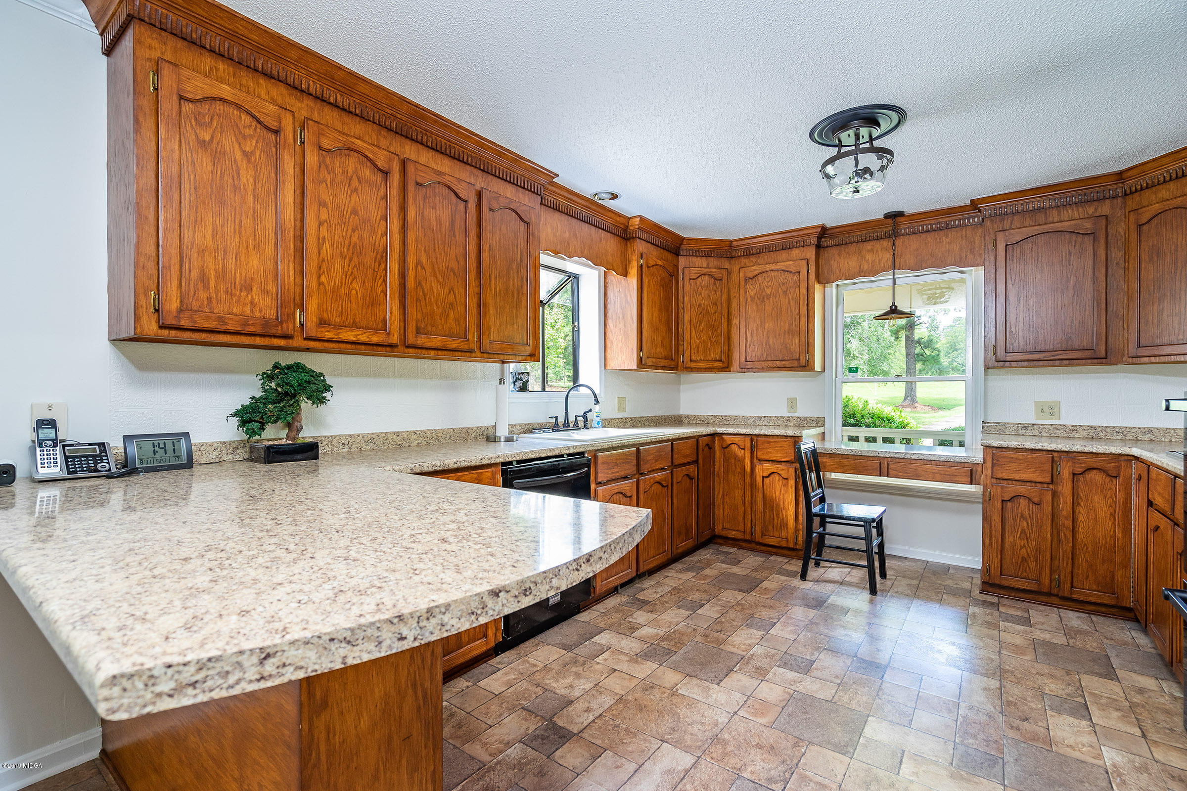 1041 Pate Road Juliette, GA 31046 - Photo 5 of 16 a kitchen with granite countertop a sink a stove and a wooden cabinets