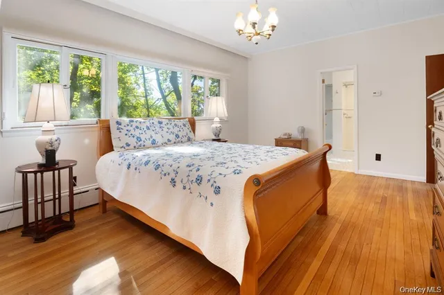 a bed sitting in a spacious bedroom next to a window