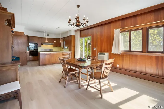 a dining room with furniture a chandelier and wooden floor