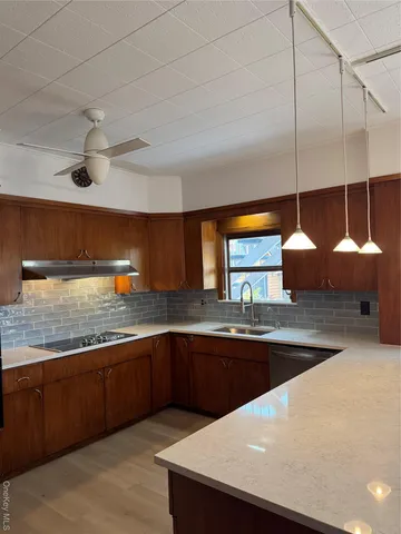 a kitchen with stainless steel appliances granite countertop a sink a counter space and cabinets