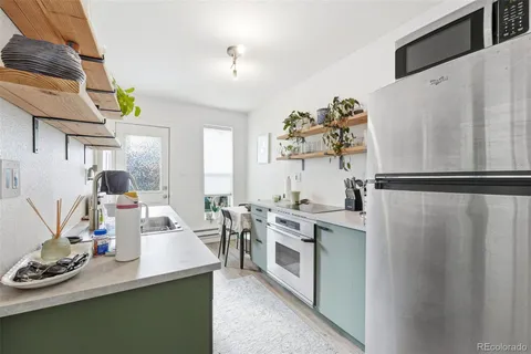 a kitchen with white cabinets and appliances
