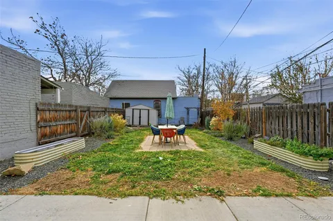 a view of a chair and table in backyard of the house