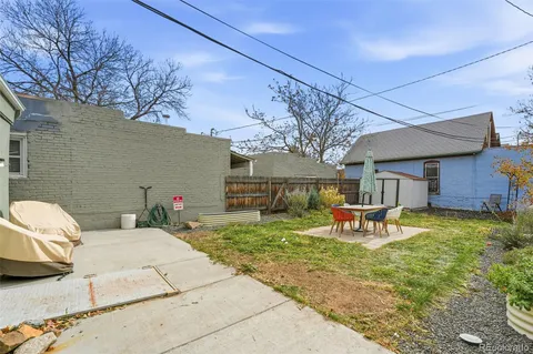a view of a backyard with table and chairs under an umbrella