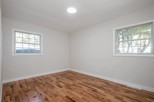 a view of a room with wooden floor and windows