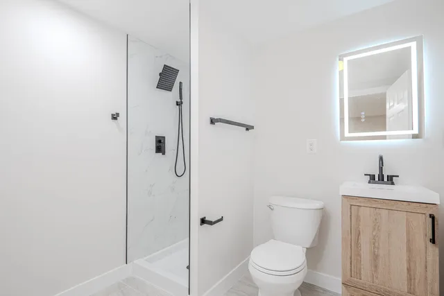 a bathroom with a sink a toilet and shower