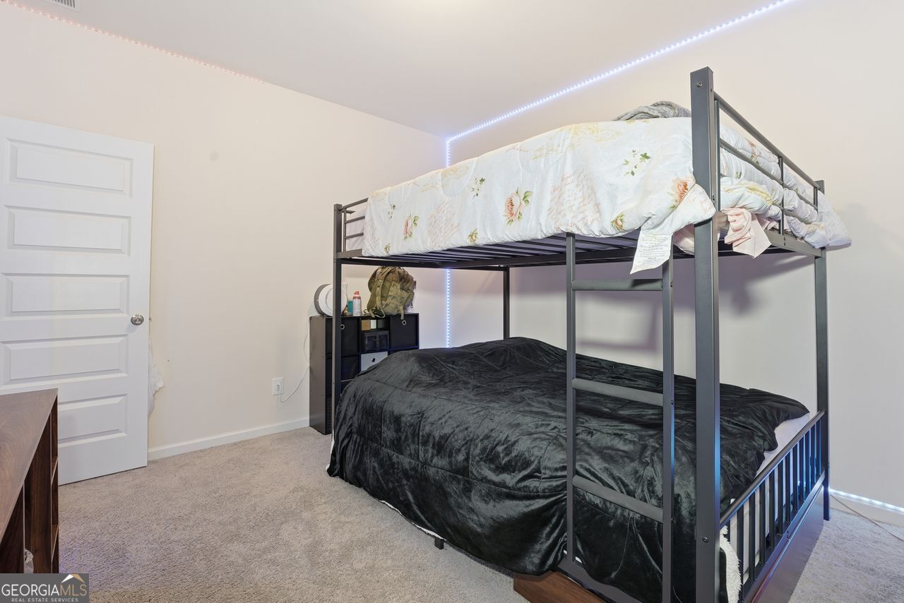 223 Malbone Street Southwest, Unit 5B Cartersville, GA 30120 - Photo 23 of 38 a bedroom with a bed a chandelier and dresser