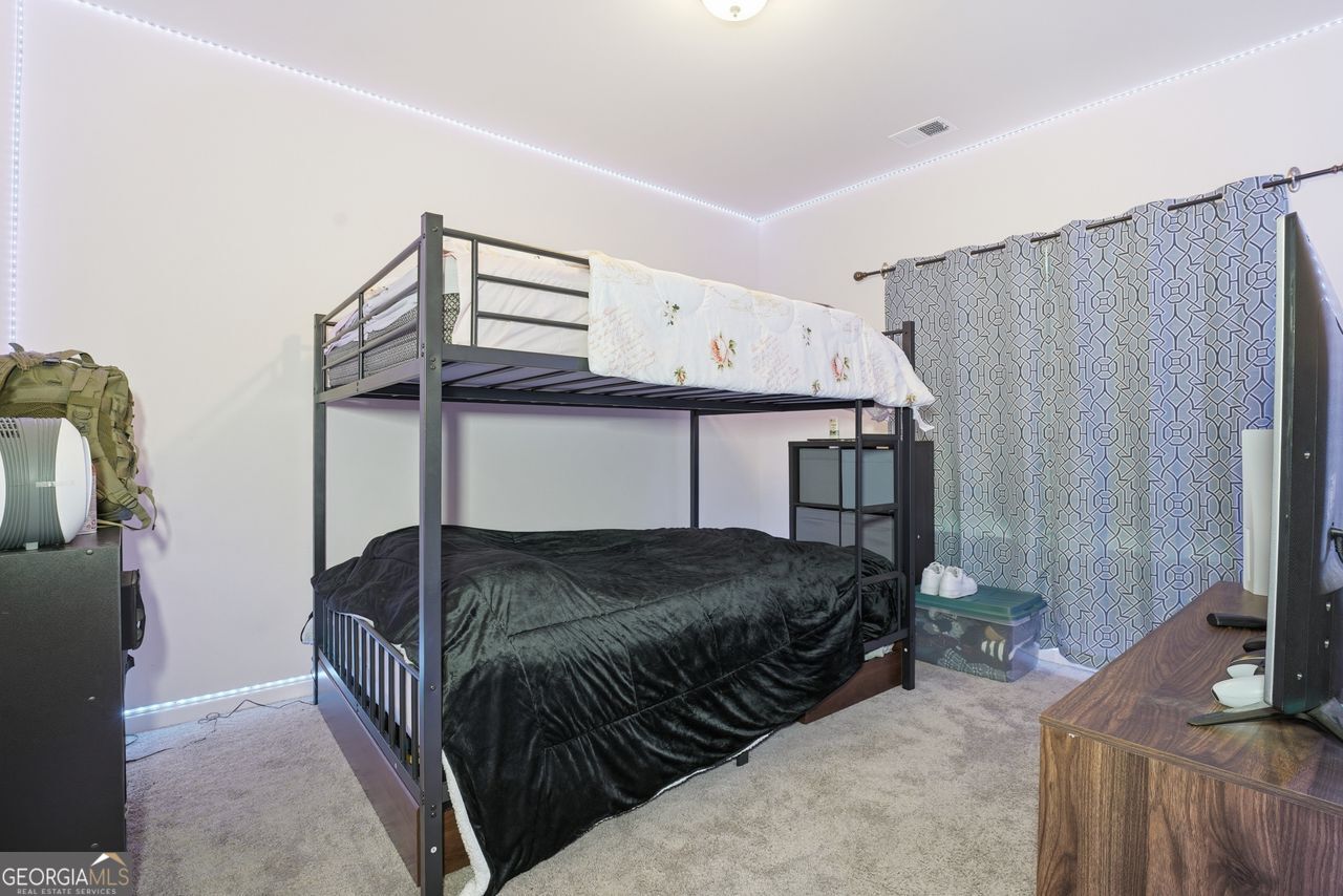 223 Malbone Street Southwest, Unit 5B Cartersville, GA 30120 - Photo 24 of 38 a bedroom with a bed and a flat tv screen on wall