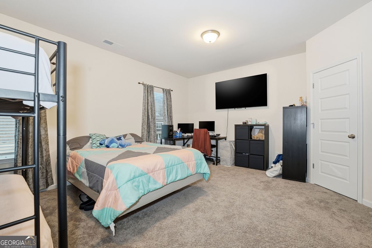 223 Malbone Street Southwest, Unit 5B Cartersville, GA 30120 - Photo 25 of 38 a bedroom with a bed and a flat screen tv