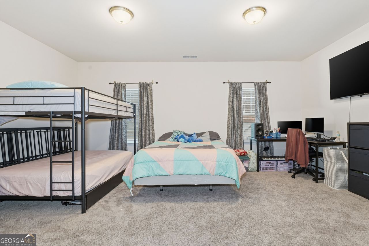 223 Malbone Street Southwest, Unit 5B Cartersville, GA 30120 - Photo 27 of 38 a bedroom with a bed and flat tv screen