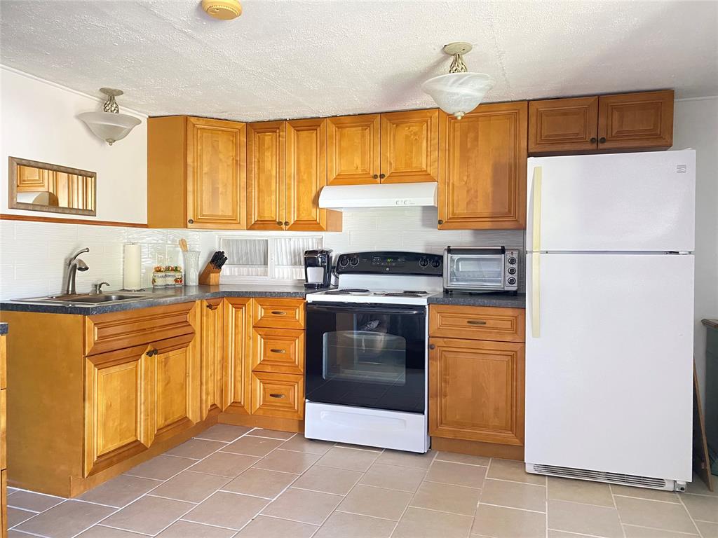 14629 Sunset Drive Delray Beach, FL 33445 - Photo 12 of 35 a kitchen with granite countertop a refrigerator a stove a sink and dishwasher
