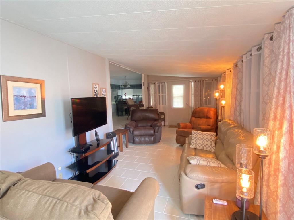 14629 Sunset Drive Delray Beach, FL 33445 - Photo 3 of 35 a living room with furniture and a flat screen tv