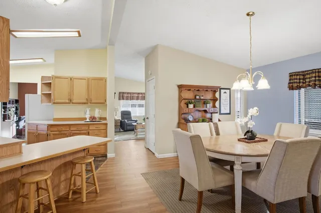 a dining room with furniture a chandelier and wooden floor