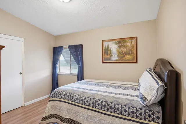 a bedroom with a bed and wooden floor