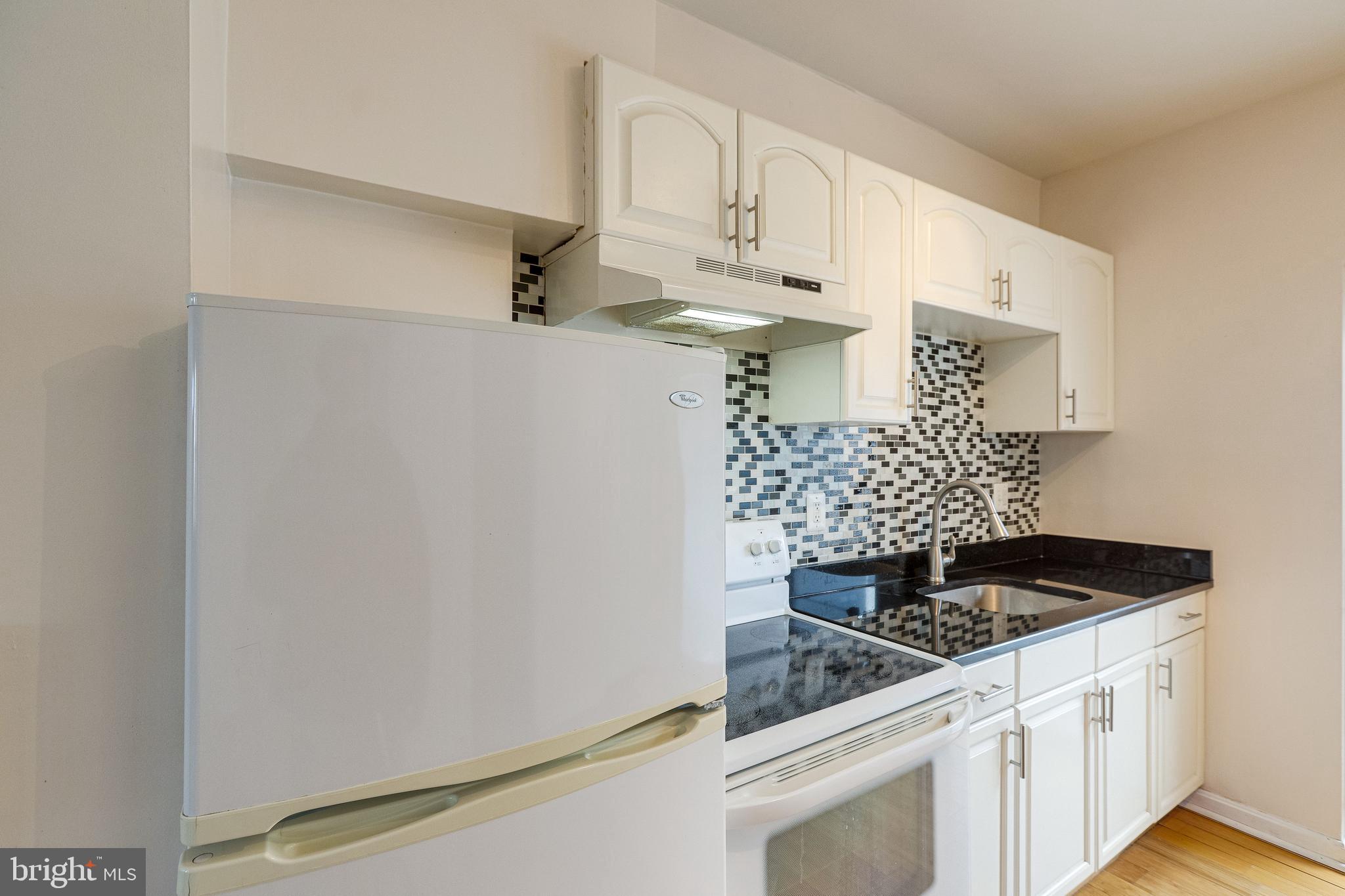 1119 3rd Street Northeast Washington, DC 20002 - Photo 12 of 31 a kitchen with white cabinets and appliances