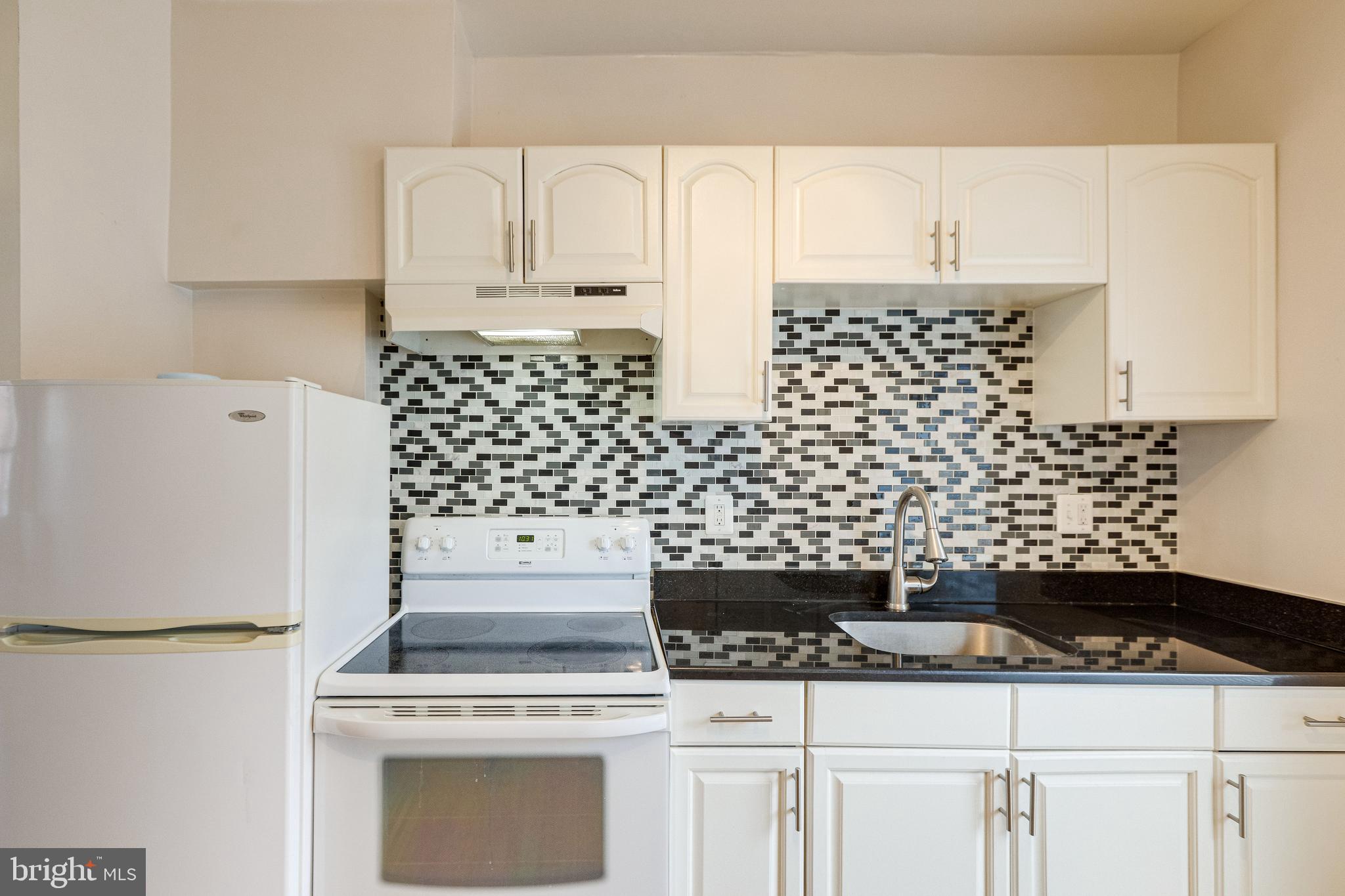 1119 3rd Street Northeast Washington, DC 20002 - Photo 13 of 31 a kitchen with white cabinets and appliances