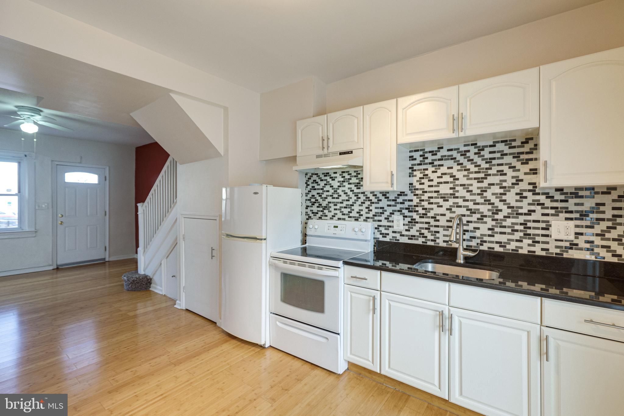 1119 3rd Street Northeast Washington, DC 20002 - Photo 15 of 31 a kitchen with granite countertop white cabinets and white appliances