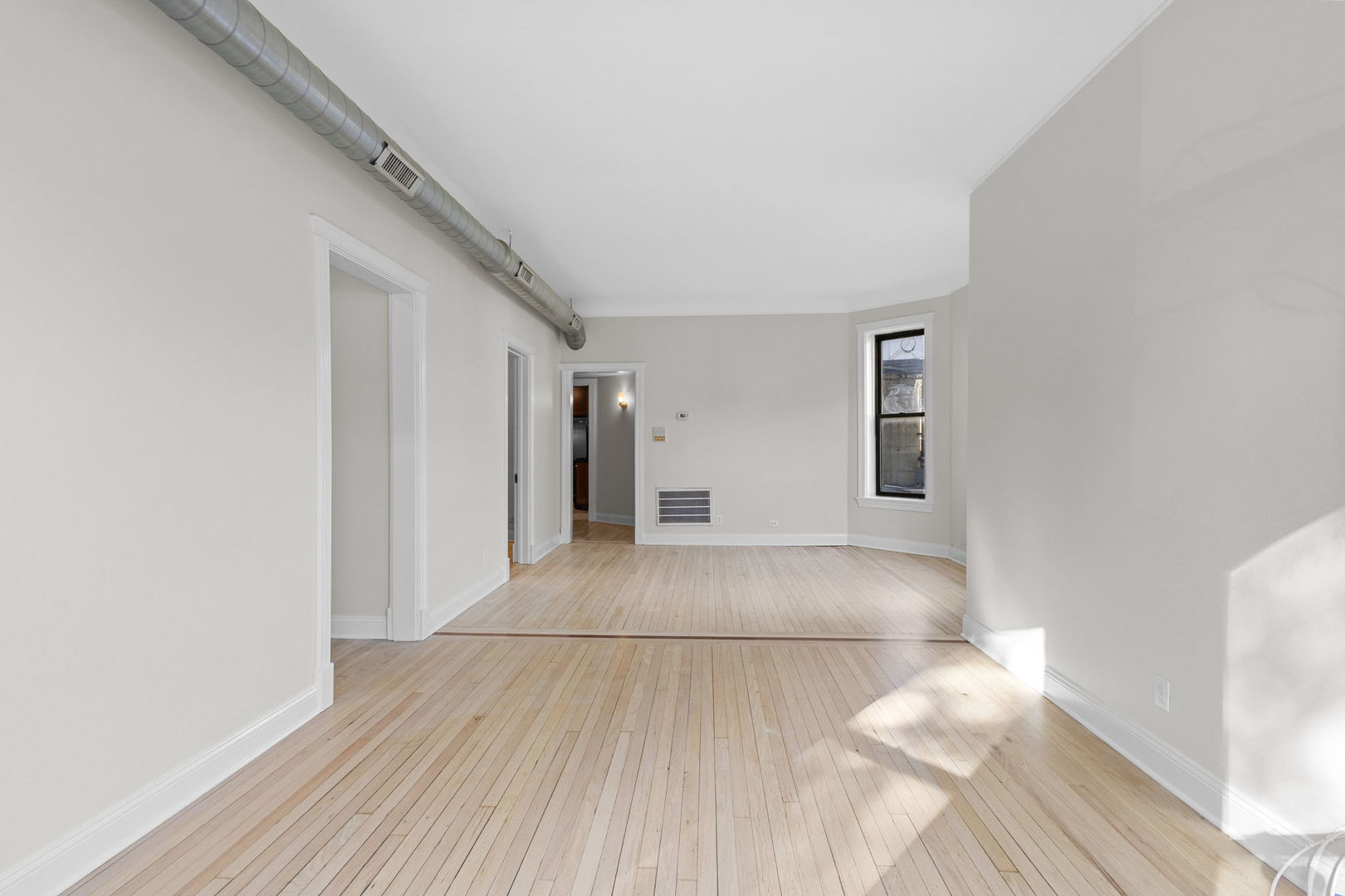 1014 West Roscoe Street, Unit 1F Chicago, IL 60657 - Photo 3 of 15 a view of livingroom with hardwood floor and hallway