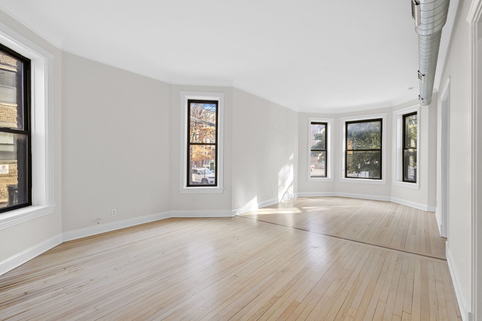 1014 West Roscoe Street, Unit 1F Chicago, IL 60657 - Photo 5 of 15 an empty room with wooden floor and windows