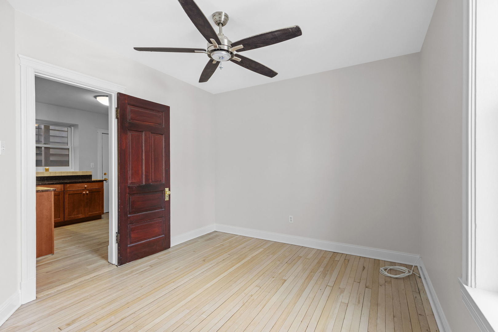 1014 West Roscoe Street, Unit 1F Chicago, IL 60657 - Photo 10 of 15 an empty room with wooden floor cabinet and windows