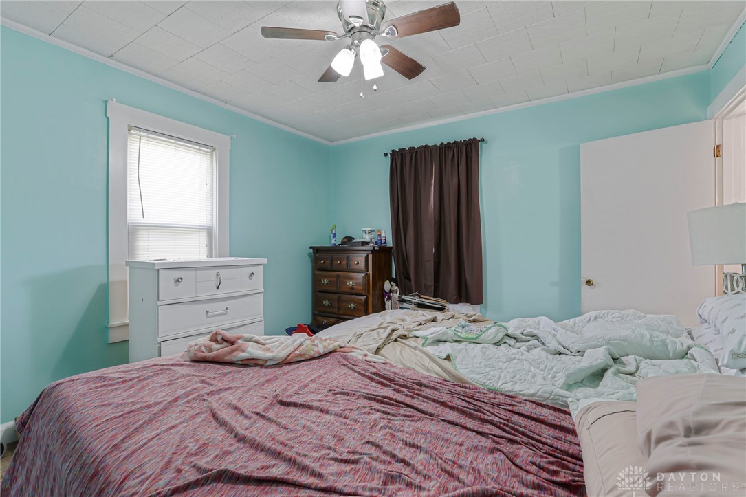 2390 Ridge Road Zanesville, OH 43701 - Photo 20 of 45 This cozy bedroom features a ceiling fan, a window, and a door, providing comfort and natural light.