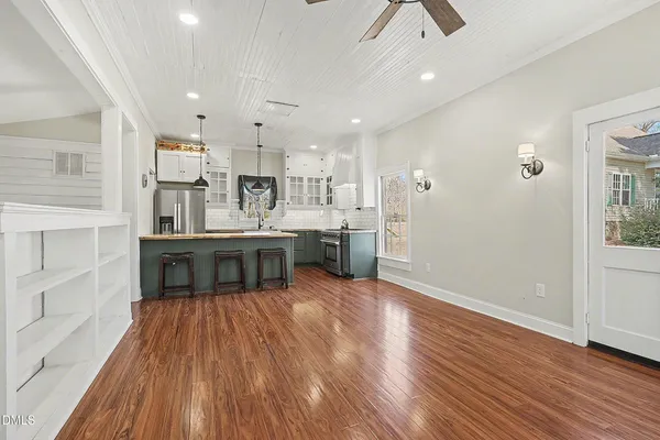 a living room with stainless steel appliances kitchen island wooden floors and view living room