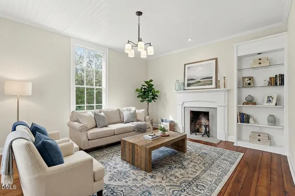 a living room with furniture a chandelier and a fireplace