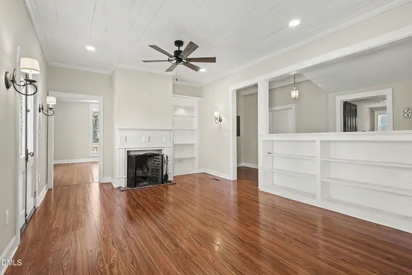 wooden floor fireplace and windows in an empty room