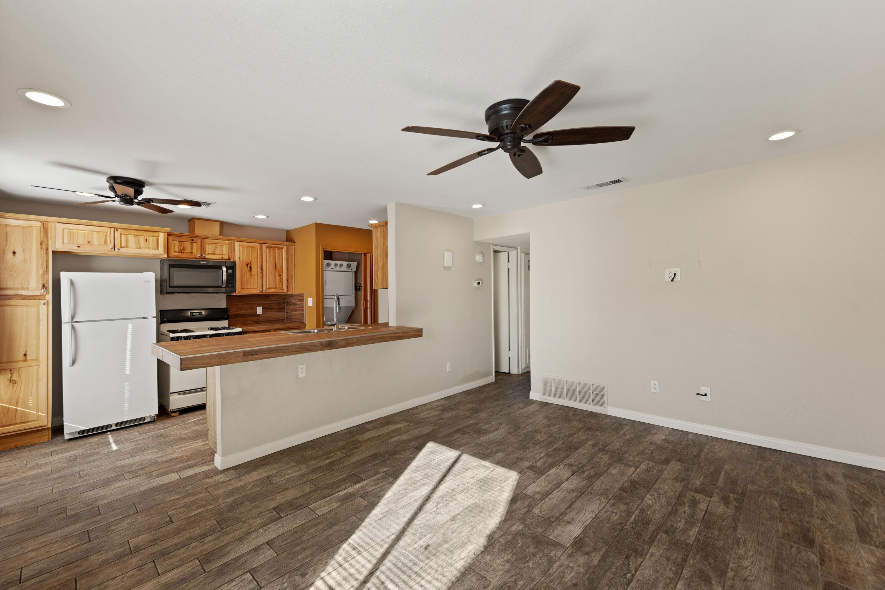 82567 Ave 48, Unit 103 Indio, CA 92201 - Photo 1 of 26 a view of a kitchen with a sink and dishwasher a refrigerator with wooden floor