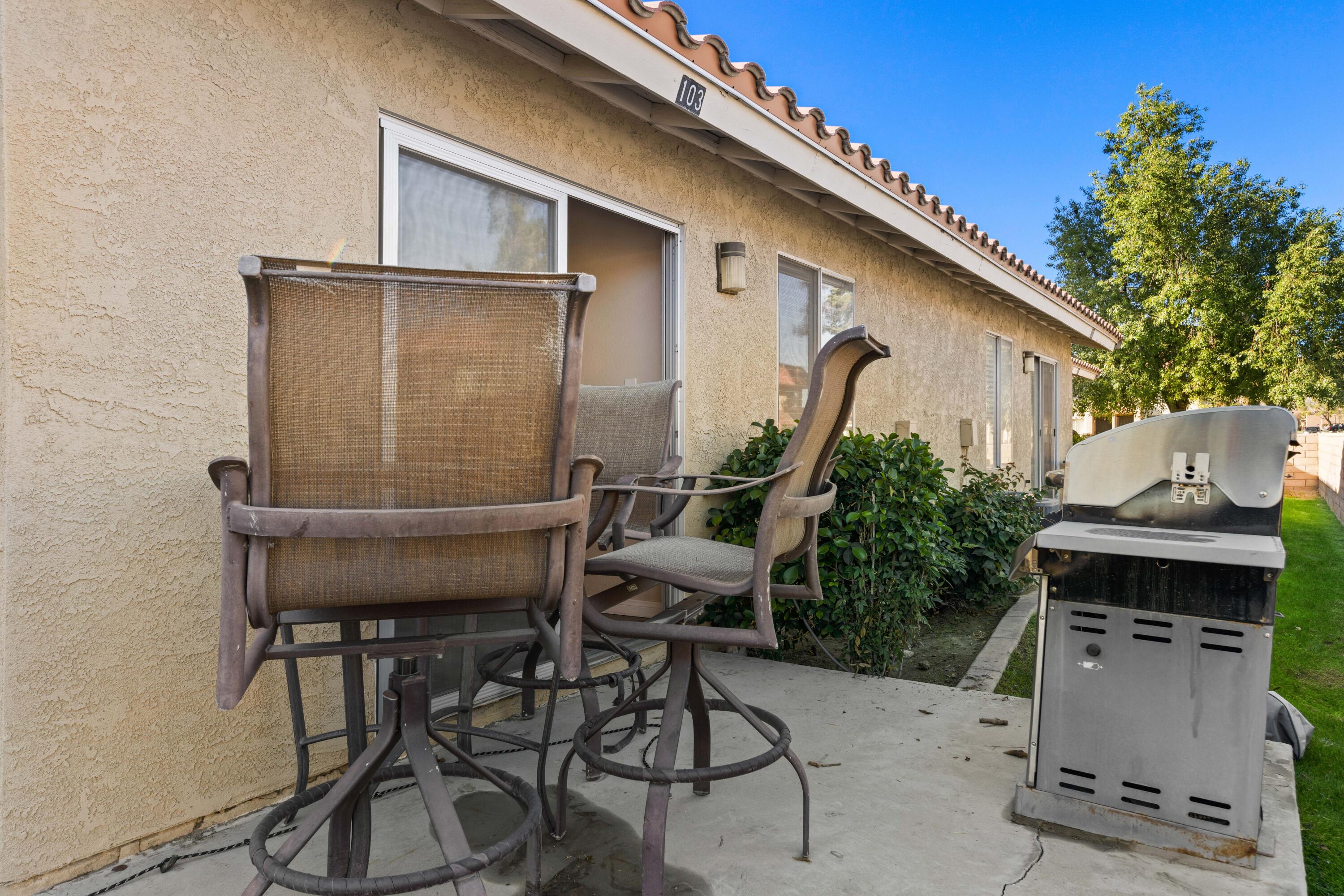 82567 Ave 48, Unit 103 Indio, CA 92201 - Photo 13 of 26 a patio with table and chairs and potted plants