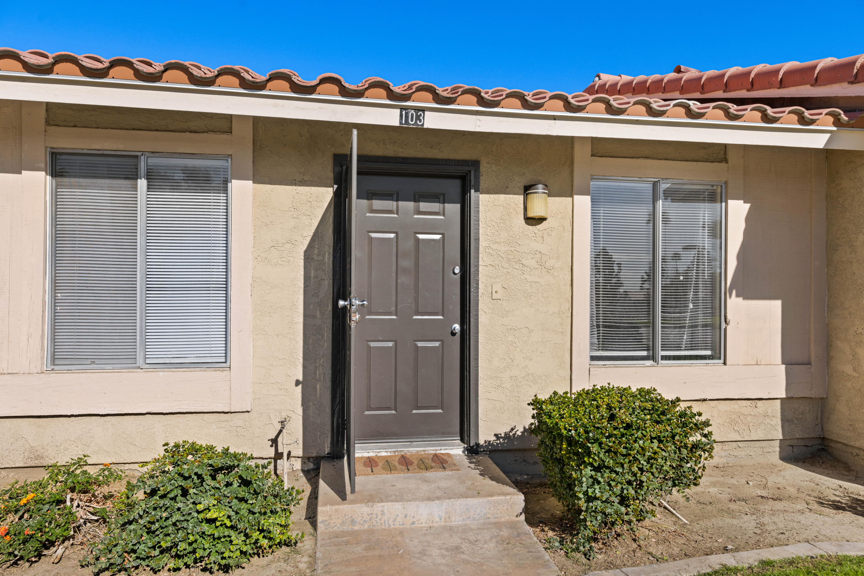 82567 Ave 48, Unit 103 Indio, CA 92201 - Photo 20 of 26 a front view of a house with a yard and garage