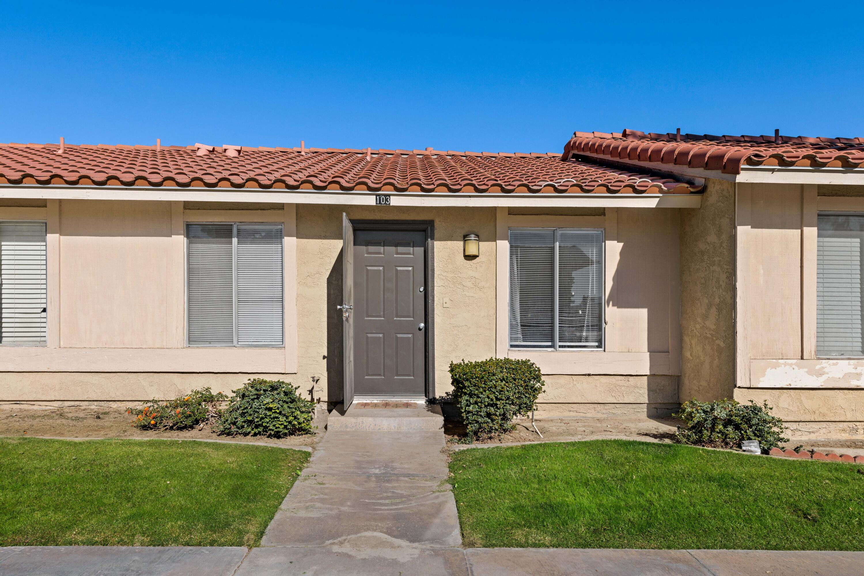 82567 Ave 48, Unit 103 Indio, CA 92201 - Photo 2 of 26 a front view of a house with a yard