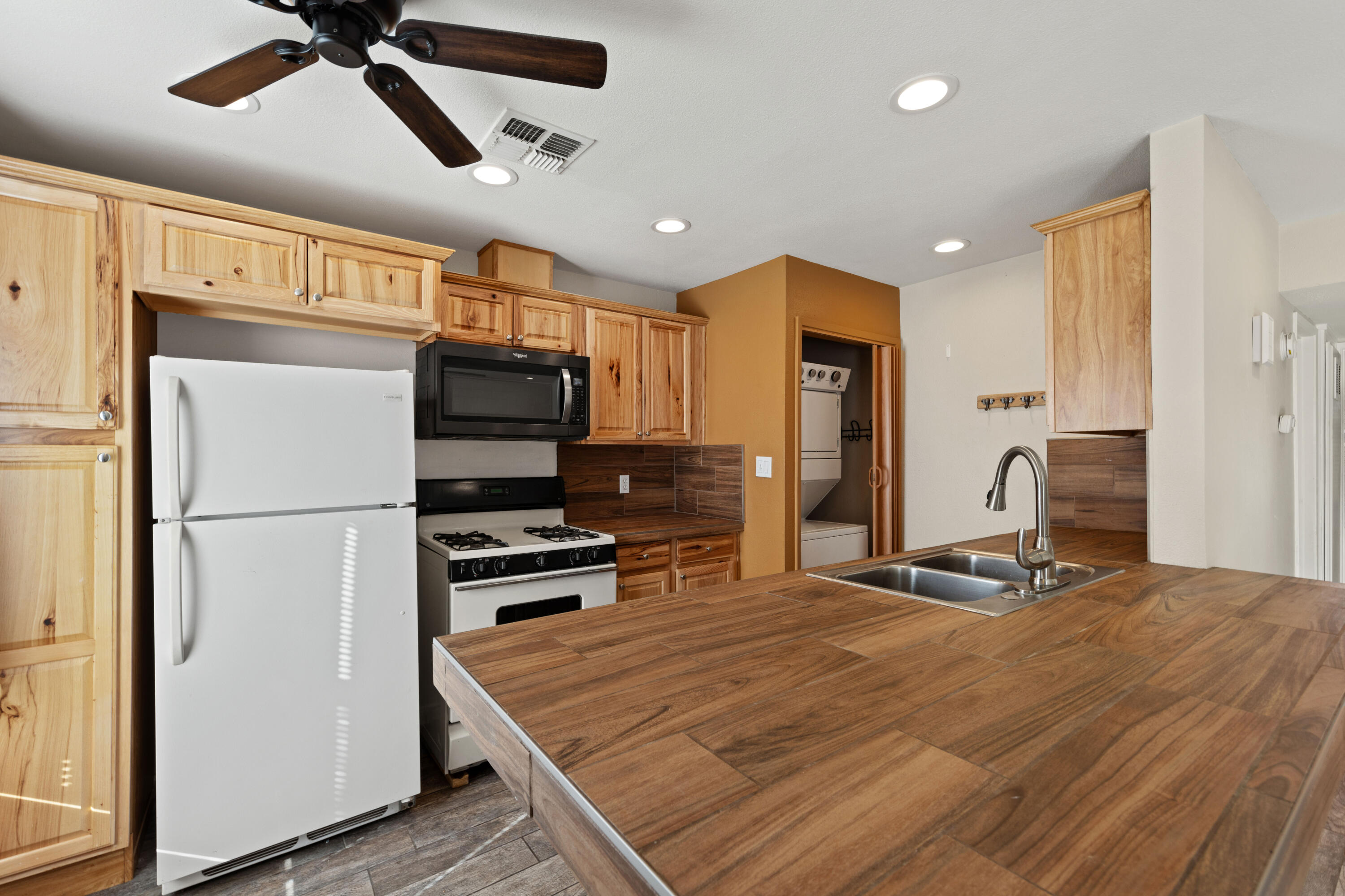82567 Ave 48, Unit 103 Indio, CA 92201 - Photo 3 of 26 a kitchen with stainless steel appliances granite countertop a refrigerator a oven a sink and white cabinets with wooden floor