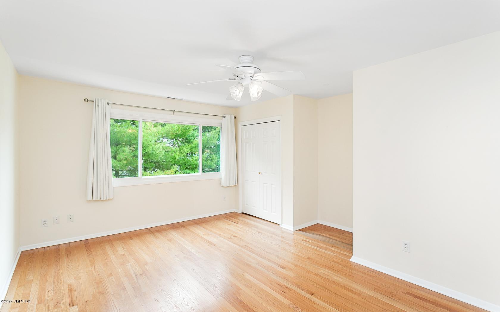 24 Whiffletree Way, Unit 24 Riverside, CT 06878 - Photo 14 of 29 an empty room with wooden floor ceiling fan and windows