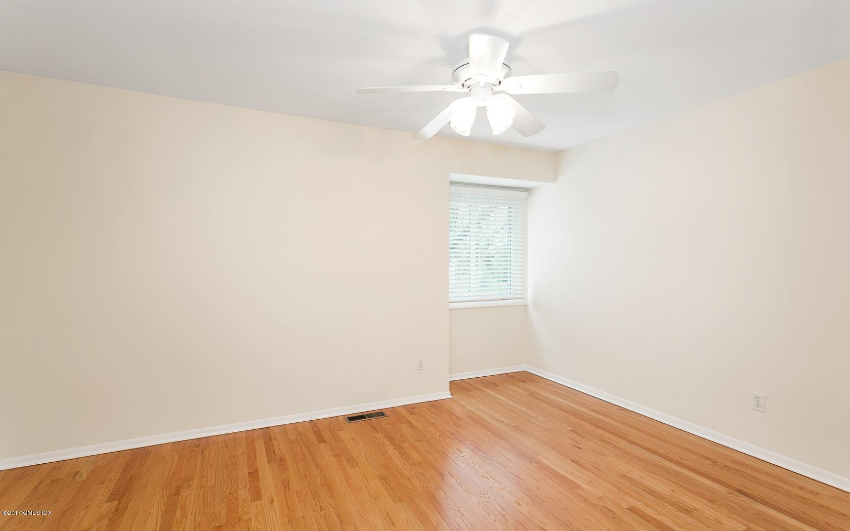24 Whiffletree Way, Unit 24 Riverside, CT 06878 - Photo 16 of 29 an empty room with wooden floor and chandelier fan