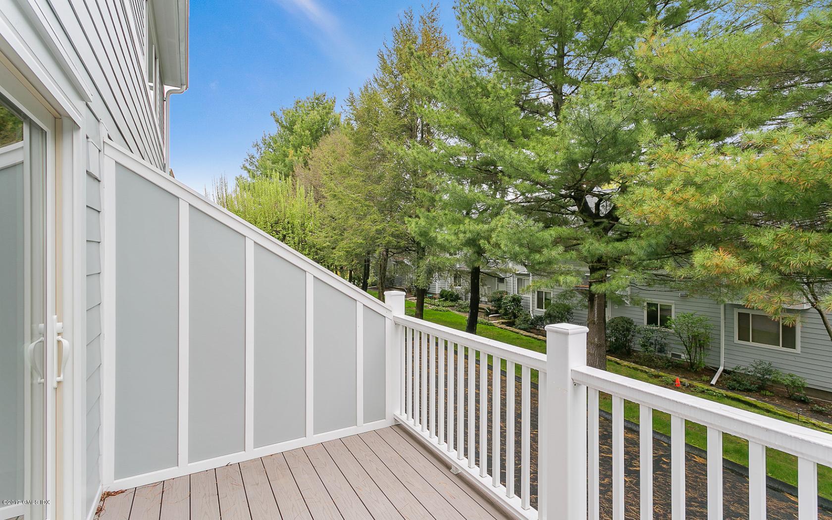 24 Whiffletree Way, Unit 24 Riverside, CT 06878 - Photo 21 of 29 a balcony with wooden floor and fence