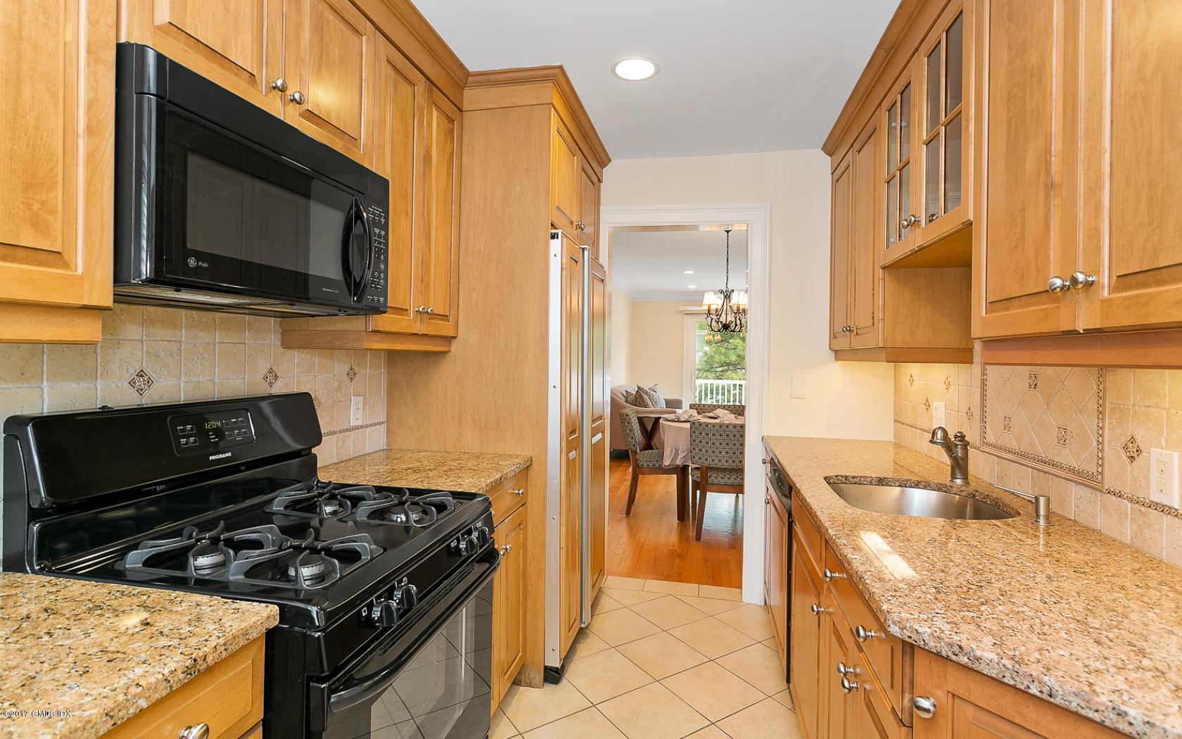 24 Whiffletree Way, Unit 24 Riverside, CT 06878 - Photo 5 of 29 a kitchen with stainless steel appliances granite countertop a stove a sink and a microwave