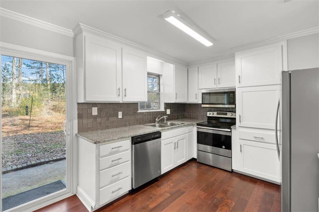 81 Russell Drive Northeast Rome, GA 30165 - Photo 18 of 38 a kitchen with stainless steel appliances granite countertop a stove a sink and white cabinets