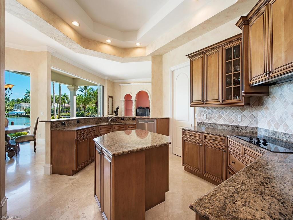 419 Mooring Line Drive Naples, FL 34102 - Photo 7 of 16 a kitchen with kitchen island granite countertop a sink stove and cabinets