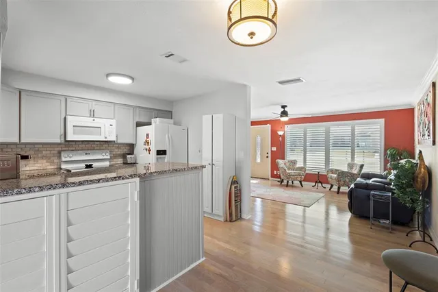 a kitchen with a large window appliances a sink and cabinets