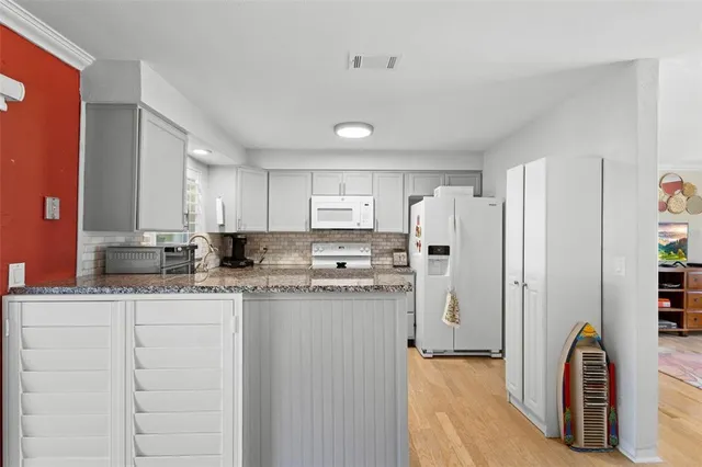 a kitchen with stainless steel appliances granite countertop a refrigerator a stove and a sink