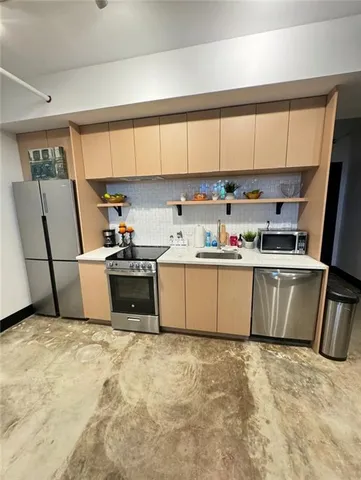 a kitchen with stainless steel appliances granite countertop a refrigerator sink and white cabinets