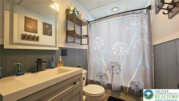 a bathroom with a sink a toilet and shower curtain