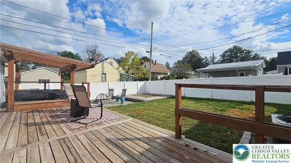 a view of a patio with table and chairs with wooden floor and fence