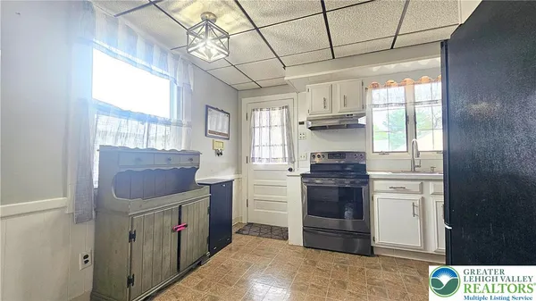 a kitchen with a stove top oven cabinets and a window