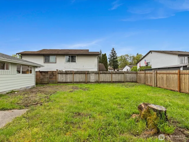 a view of a backyard with a garden and wooden fence