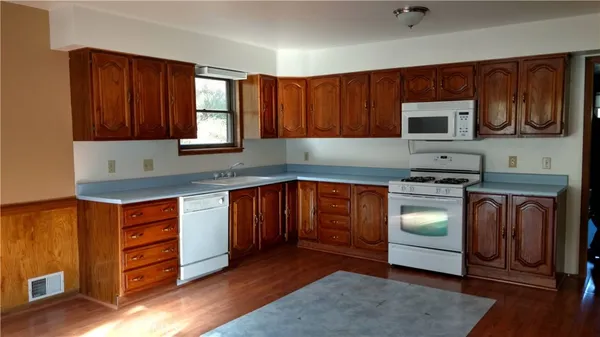 a kitchen with granite countertop wooden cabinets stainless steel appliances and a window